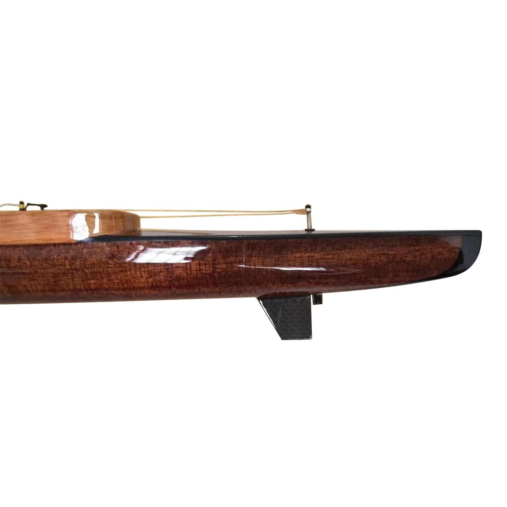 Side view of the ZJ Handcrafted Rowing Boat Model Miniatures (Wood) by zijie, showcasing a rich brown finish with a black-edged hull. Part of the deck and mast base are visible as it rests on a white background.