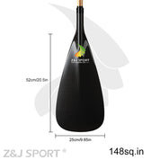 The image features a ZJ SPORT blade for outrigger canoe paddles, made of black carbon fiber with a PMI foam core. It measures 52cm by 25cm, covering an area of 148 sq in, and displays the Z&J SPORT logo with a stylized flame.