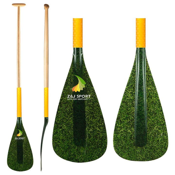 Three ZJ SPORT Hybrid Outrigger Canoe paddles, two full-length and one close-up, display grass-textured fiberglass blades and wooden-handled shafts. The distinctive yellow antiskid grip area enhances the design, with the ZJ SPORT logo prominently showcased on all paddles.