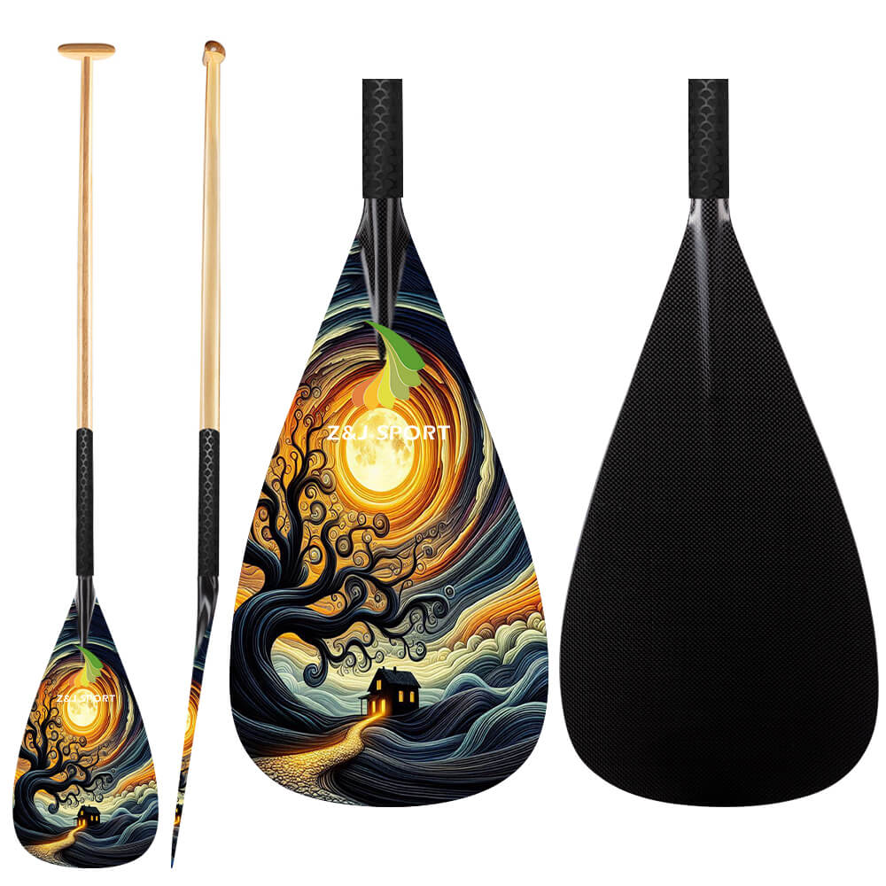 The three waka ama paddles from ZJ SPORT include two with swirling night sky designs featuring a tree and illuminated house, and the third having a solid black carbon blade. Their wooden ergonomic T-handles beautifully complement the detailed blades of the ZJ Hybrid Outrigger Canoe VAA Paddle.