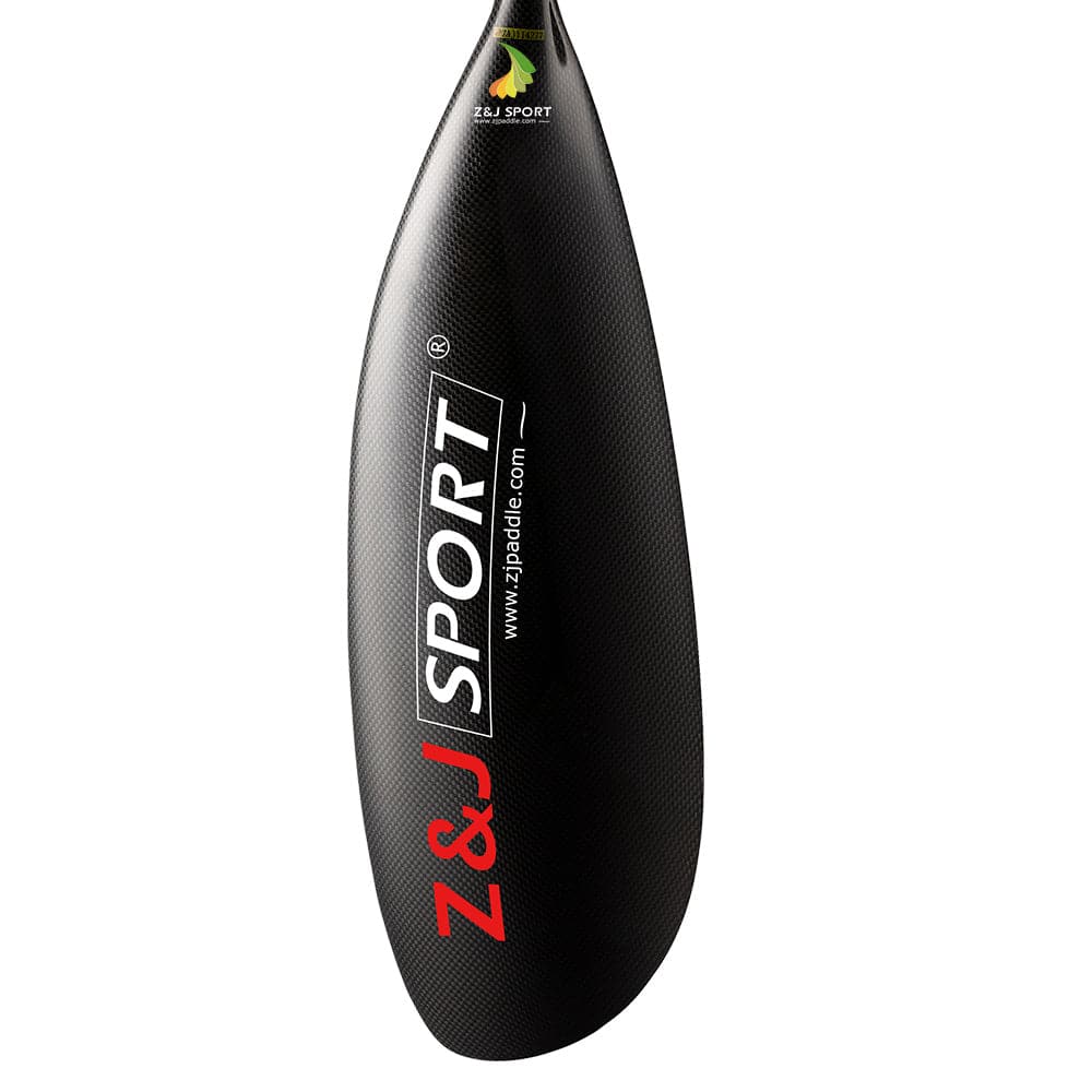 The close-up shows a black ZJ SPORT kayak paddle blade, crafted from sleek carbon fiber with a textured surface. The ZJ SPORT logo appears in red and white beneath a small yellow and green leaf logo, ideal for perfecting precise strokes.